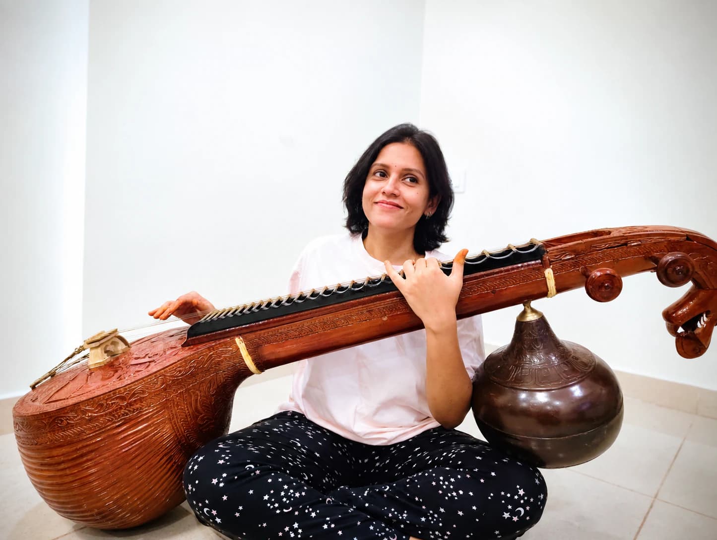 Priya seated with a veena